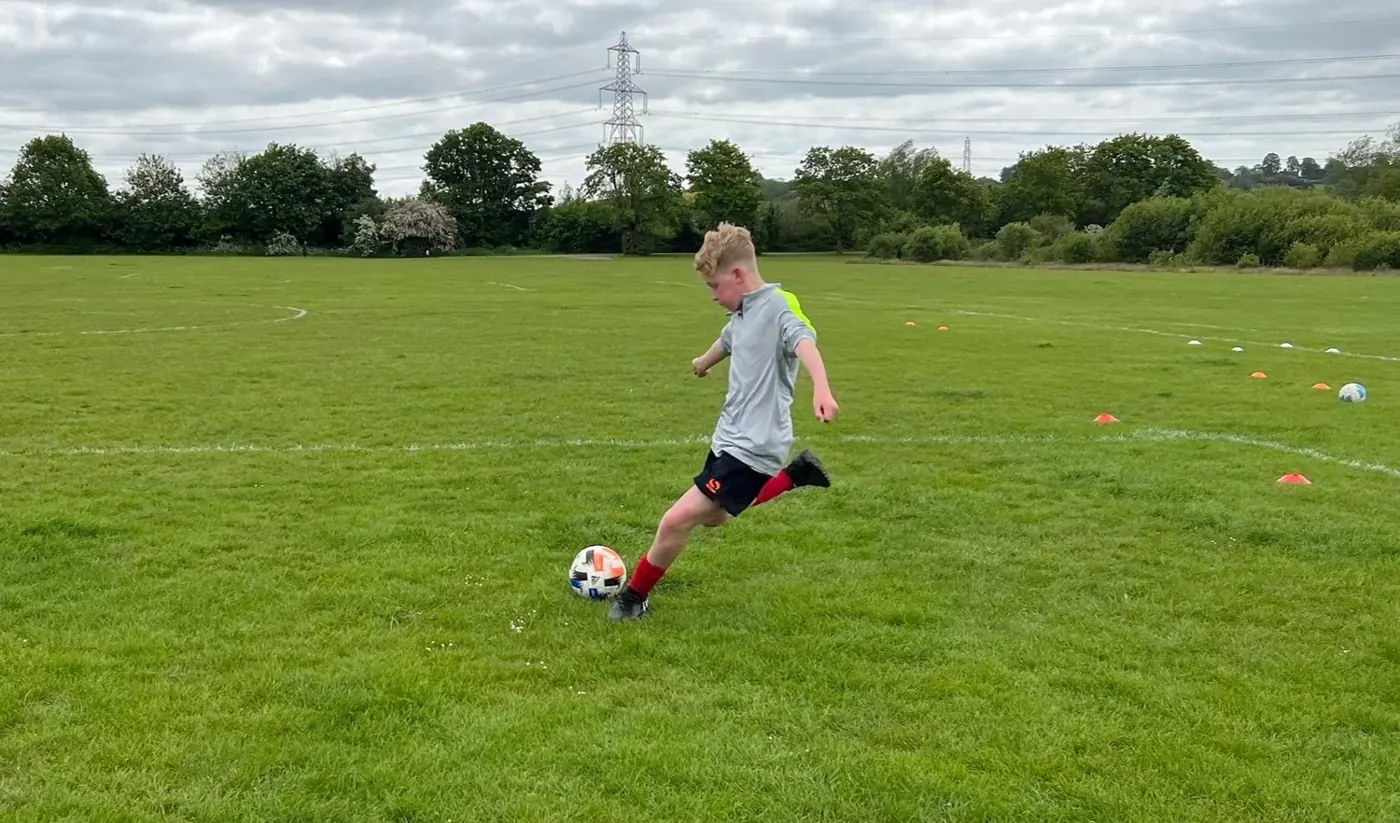 Young player striking a ball during a 1-2-1 session